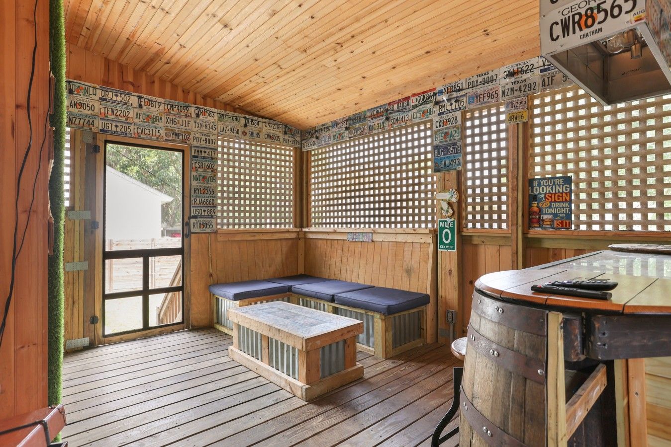 Un interior de madera con un banco, una mesa y un barril.