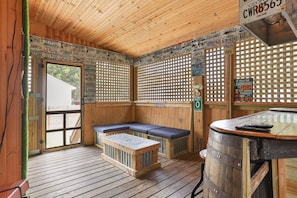A wooden interior with a bench, a table, and a barrel. - Southern Comfort Bar (Savannah)