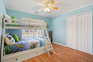 A bunk bed with a ladder, a ceiling fan, and a window with a view. - Southern Comfort Bar (Savannah)