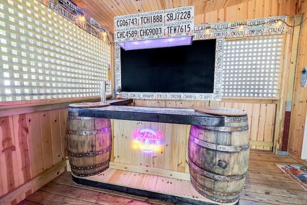 A bar area with wooden walls, a neon sign, and Georgia license plates. - Southern Comfort Bar (Savannah)