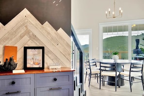 Une cuisine moderne avec un pare-feu en bois disposé en motif chevron, un tableau encadré et un plan de travail en bois.