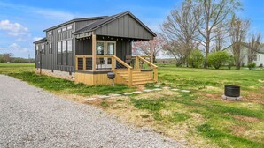 Une maison moderne dotée d’une terrasse en bois et d’un espace extérieur couvert.