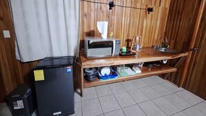 A compact kitchen with a microwave, sink, and small refrigerator. - Elida Lodge Monteverde (Monteverde)