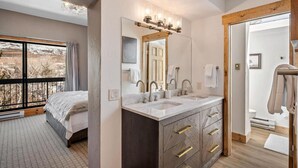 Un baño moderno con un espejo grande, lavamanos dobles y un mueble de tocador de madera.