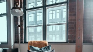 A modern room with a leather armchair, a small round table, and a floor lamp. - Massive Downtown Seattle Loft - Free Parking Included!  (Seattle)