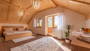 A bedroom with a wooden ceiling, a bed, a nightstand, a potted plant, and a window with curtains.
