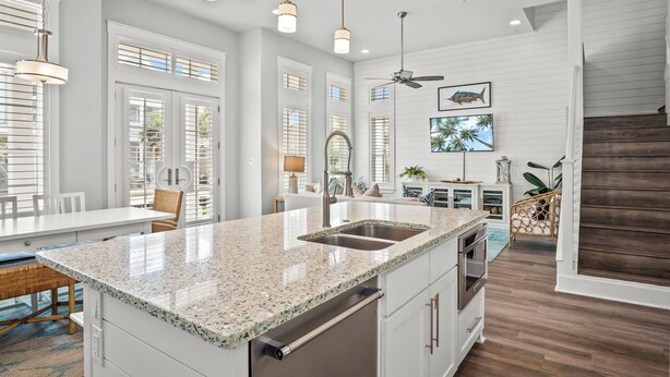 A modern kitchen with a granite countertop, stainless steel sink, and built-in oven. - Southampton 239 BE (Port Aransas)
