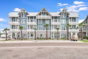 A large, multi-story hotel with a symmetrical facade, multiple balconies, and a covered loading dock. - Tarpon Tango TC 8103 (Port Aransas)