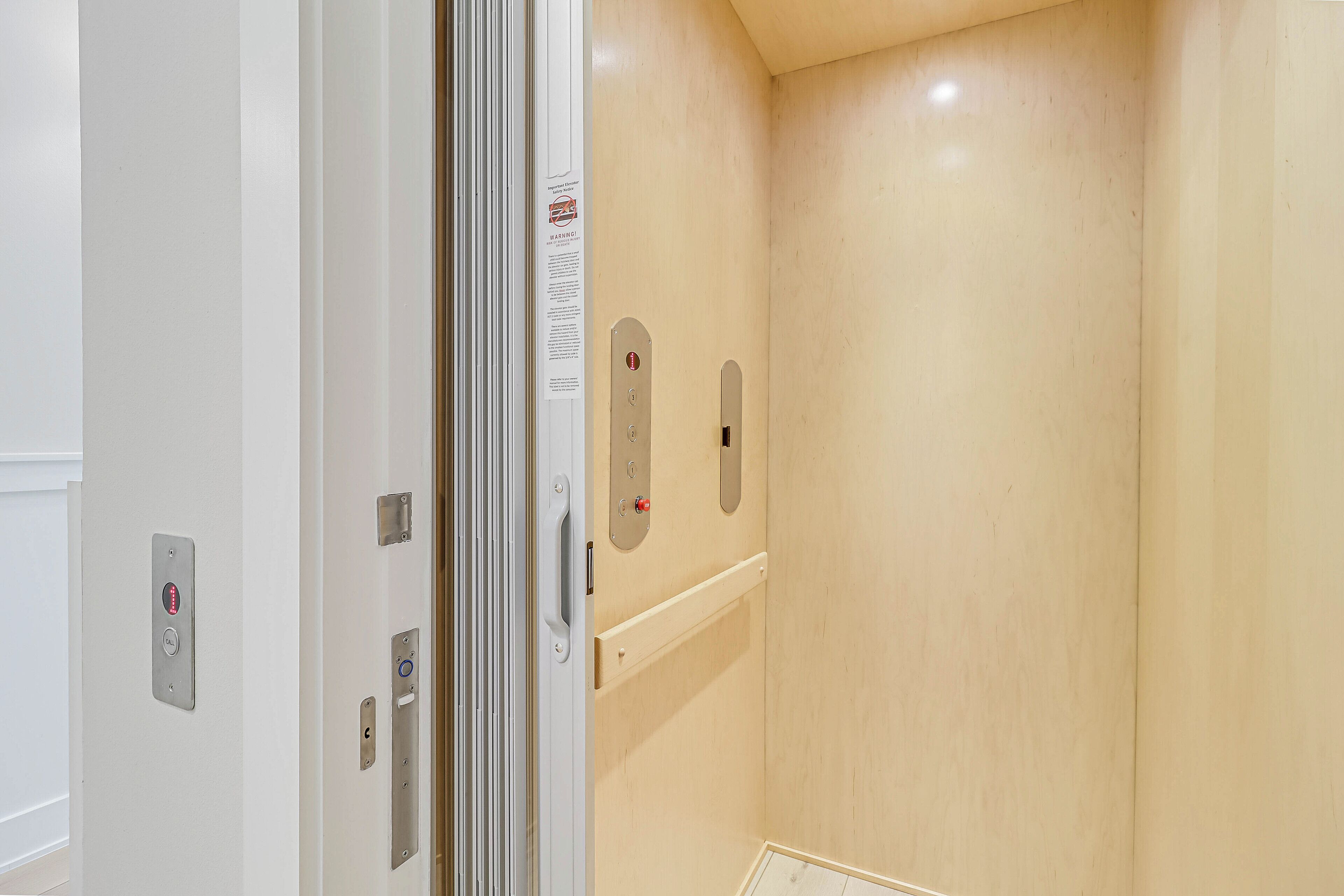 A modern elevator with a digital display and a metallic handrail.