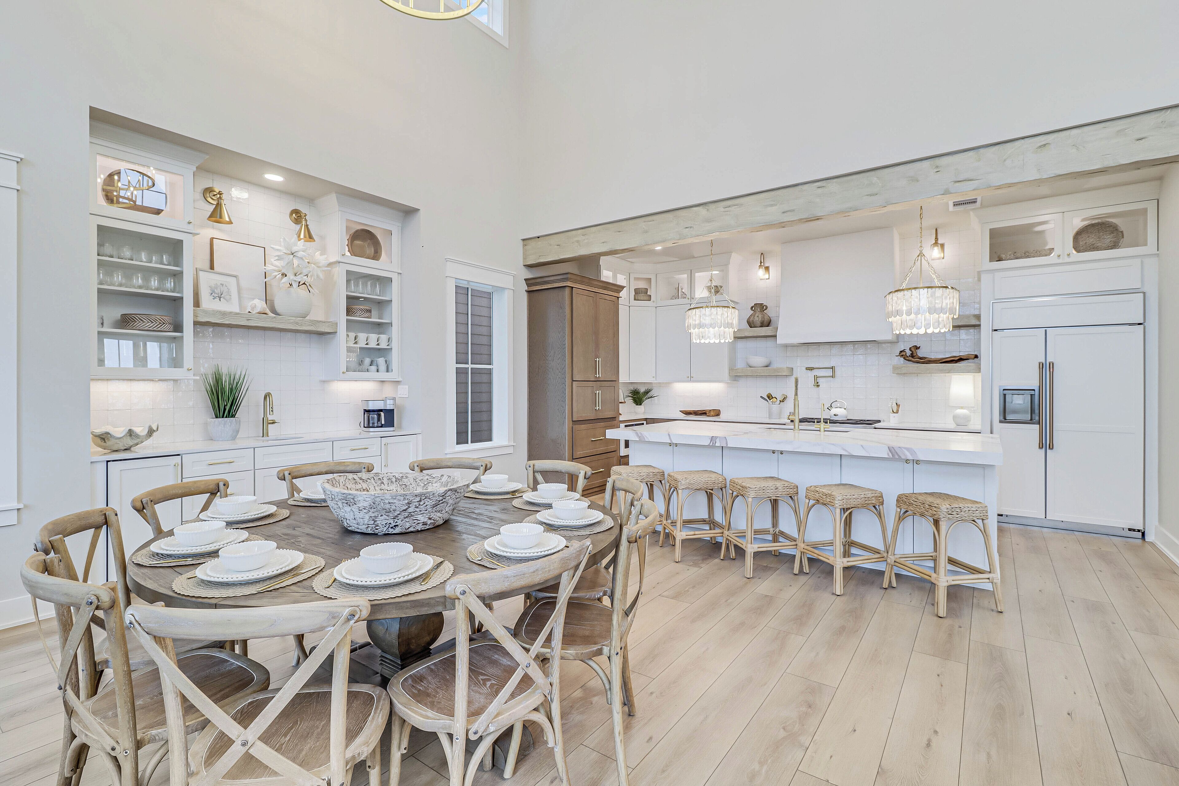 A spacious kitchen with a central island, wooden chairs, and built-in shelving.
