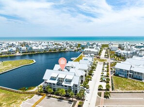 A coastal residential area with houses along a waterfront, a marina, and a clear view of the ocean. - Easy Breezy 225 TEA (Port Aransas)