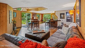 A modern interior with a dining area, a kitchen, and a living room with a sofa and a coffee table. - Priest Lake - Escape to the Lake (Nordman)