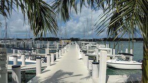 A marina with a wooden dock leading to multiple moored boats. - Aqua de Vista - Beachfront Villa w/ Stunning Sea Views in Central Abaco, BS (Joe's Creek)