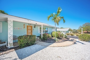 A beachfront property with a sign reading 'BEACH HOUSE,' a palm tree, and a gravel driveway. - 5 Minutes to Madeira Beach • Private Cowboy Pool (Seminole)