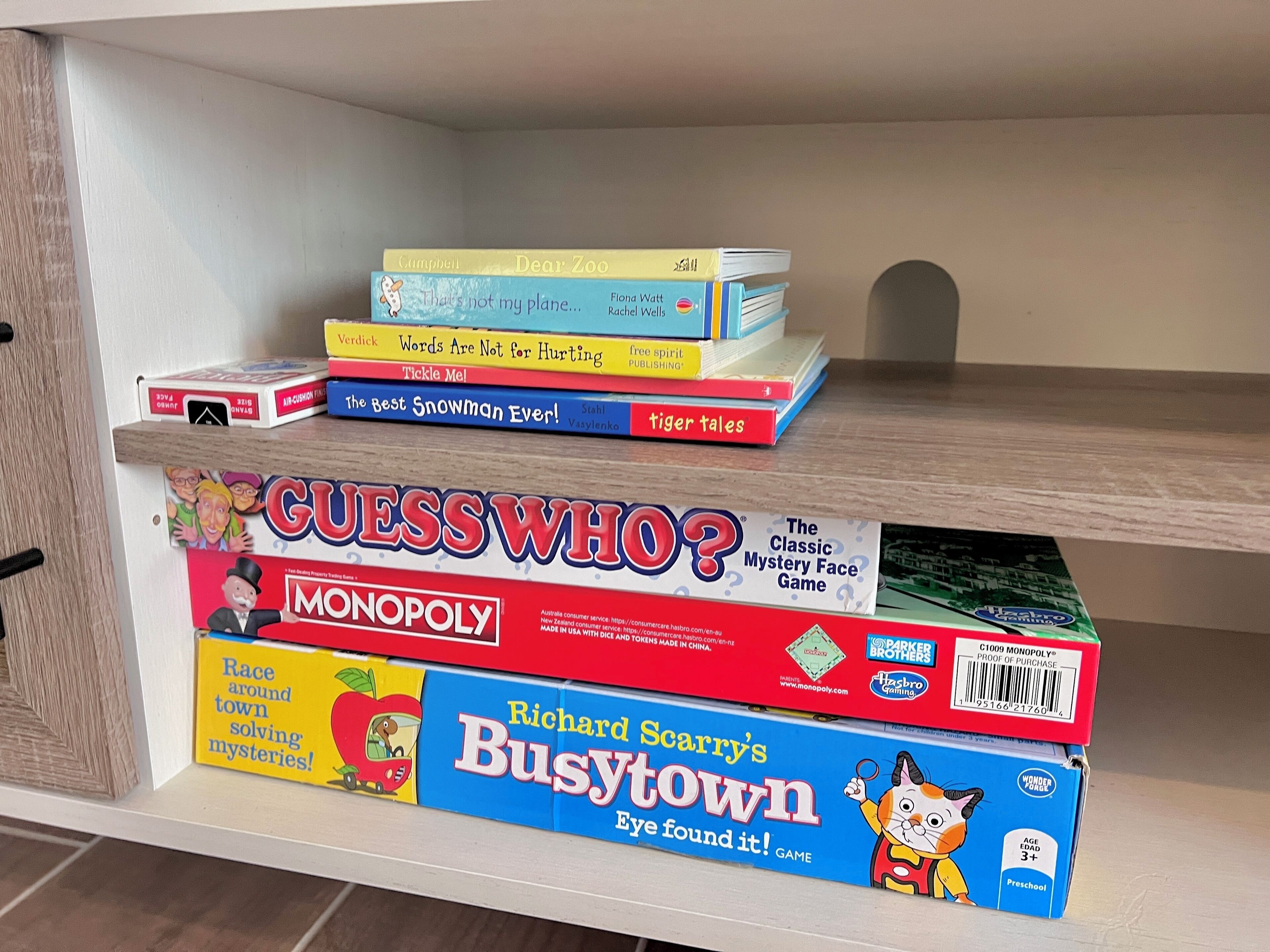 A shelf with various board games and books.