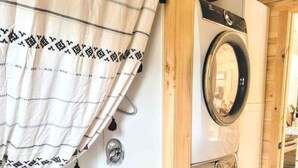 Een kleine wasruimte met een wasmachine en een bad.