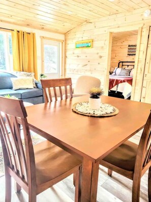 Un intérieur en bois comprenant une table à manger, des chaises, un canapé et un lit.