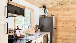 Een moderne keuken met houten kastjes, een roestvrijstalen koelkast en een inbouwoven.