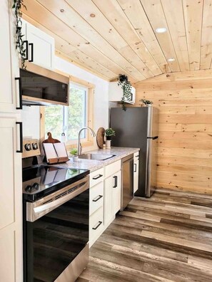 Una cocina moderna con armarios de madera, un refrigerador de acero inoxidable y un horno empotrado.