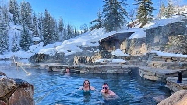A hot spring with clear water surrounded by snow-covered rocks and trees. - First Tracks 2br 2bath Steamboat Heaven (Steamboat Springs)