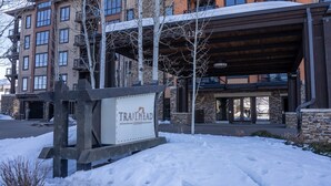 A sign for Trailhead Lodge with a modern building in the background. - First Tracks 2br 2bath Steamboat Heaven (Steamboat Springs)