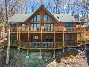 A two-story log cabin with a balcony and multiple windows. - Rustic Lakeview Cabin Escape featuring Billiards, Free Daily Attraction Tickets & Close to Big Cedar (Ridgedale)