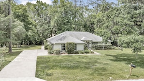 A single-story house with a front yard, a driveway, and a mailbox. - Your home away from home! Pet friendly & 5 minutes from WEC. (Ocala)