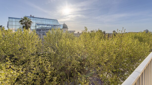 A modern building with a glass facade and a dome structure in the background. - Studio Crivelli - Welkeys (Hyères)