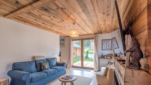 A cozy living room with a blue sofa, a wooden coffee table, and a fireplace with a bear statue.