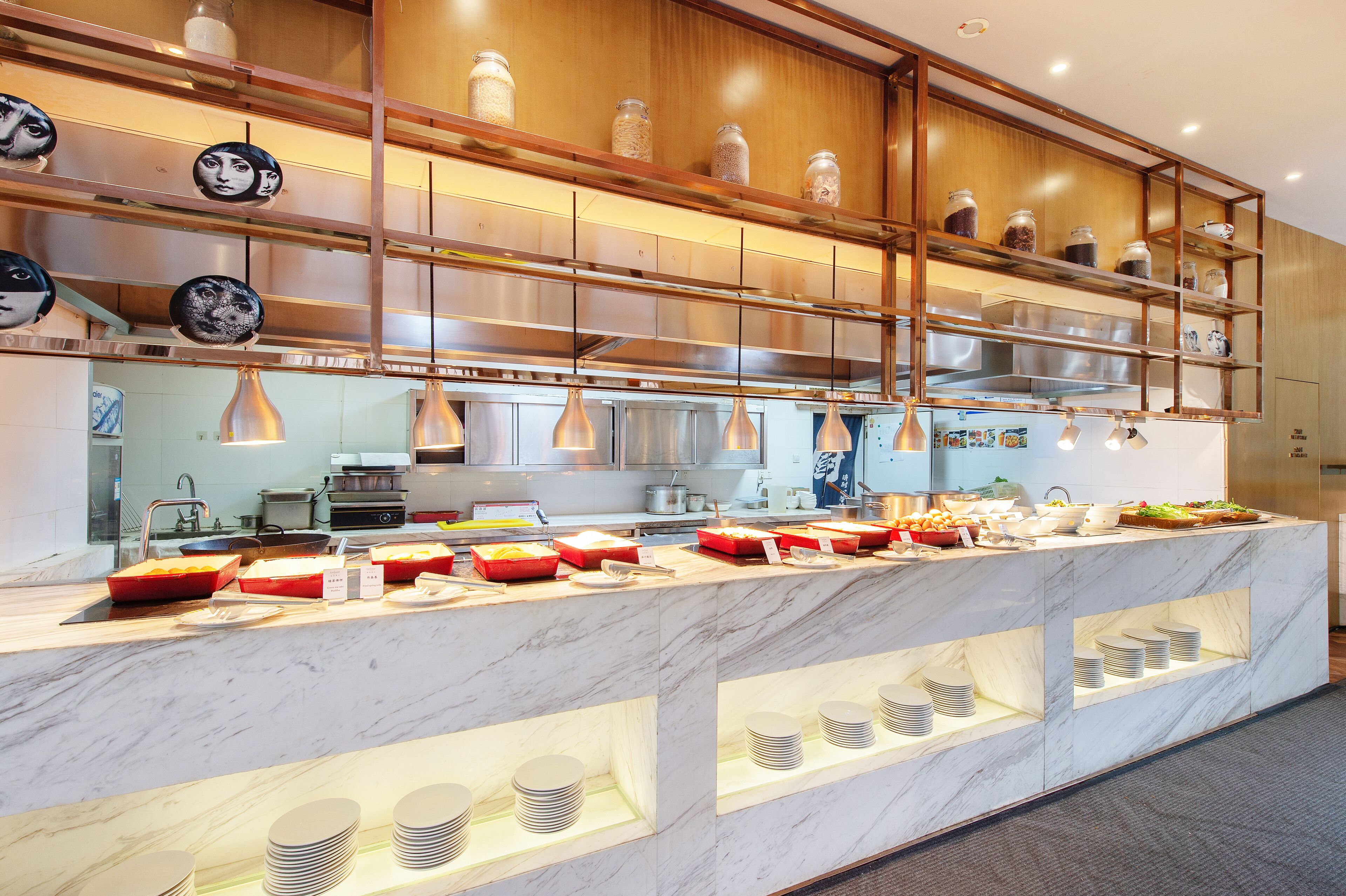 Cozinha moderna com bancadas de mármore, eletrodomésticos de aço inoxidável e um serviço de buffet.
