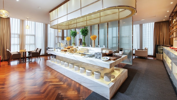 A modern hotel lobby with a marble reception desk, seating area, and a large window with curtains. - UrCove Hefei Eco-Tech Development Area (Hefei)