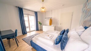 A bedroom with a bed, a desk, and a chair. - River Lux Suite | 5min to HBF (Wetzlar)