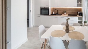 A modern kitchen with white cabinets, a wooden countertop, and a built-in oven. - 2 bedroom gorgeous apartment in Biskupiec (Biskupiec)