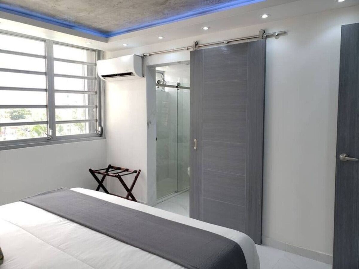 Ein modernes Schlafzimmer mit Bett, Dusche und Kleiderschrank.