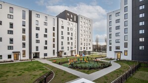 A modern apartment complex with multiple buildings, a playground, and well-maintained lawns. - Walerego Sławka Cosy Studio (Kraków)