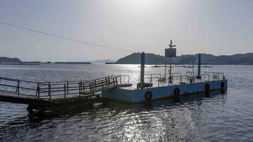 Een veerboot aanmeren in een kalm water met een heldere lucht.