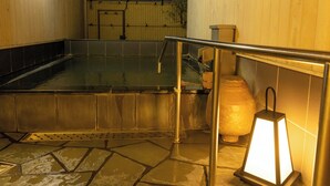 A hot spring area with a stone floor, metal railings, and a lantern. - Shiozaki Onsen Awajishima kaijyo Hotel (Minamiawaji)
