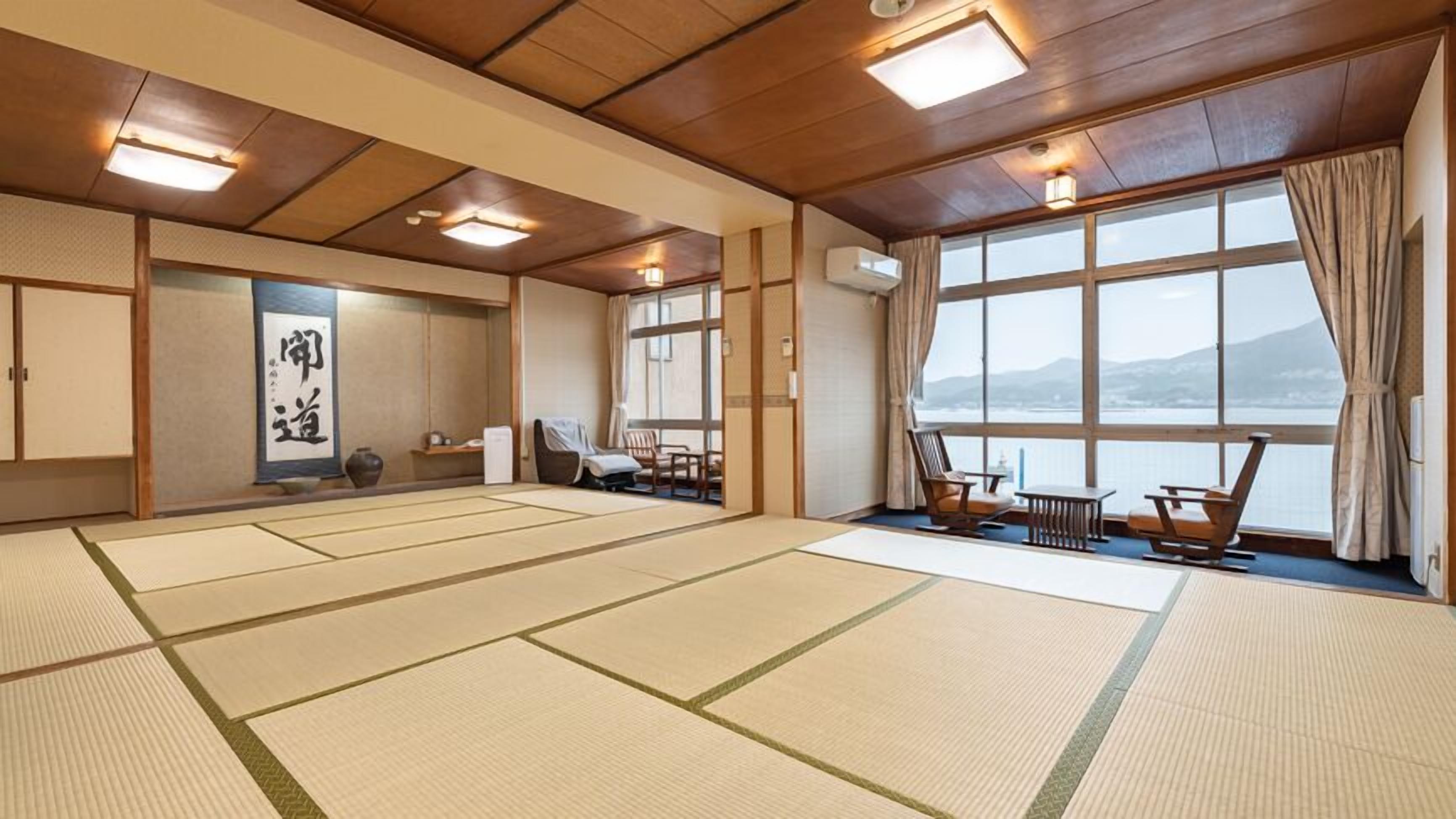 Una habitación con tatami y vistas al mar, techo de madera y decoración tradicional japonesa.