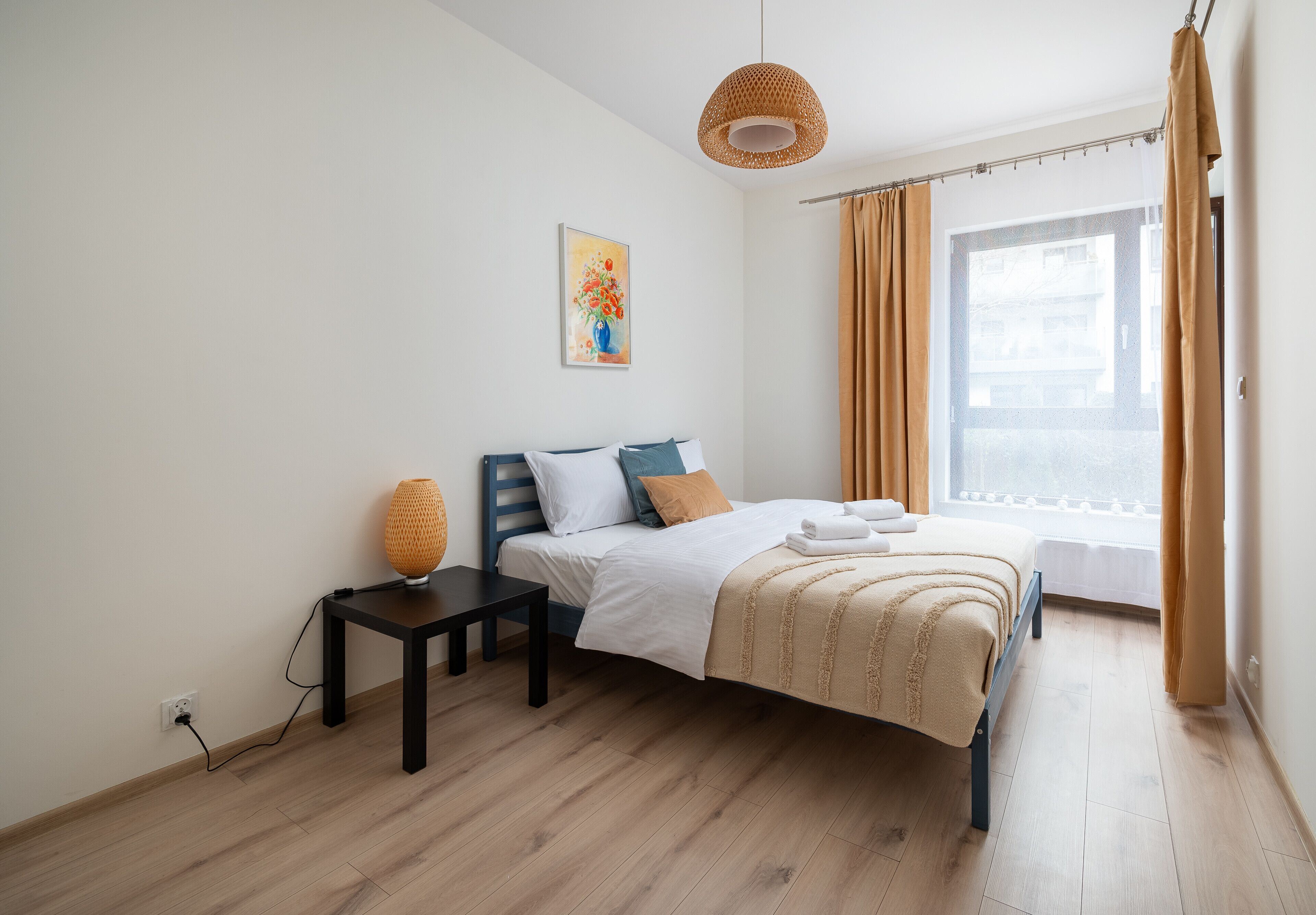Ein ordentlich eingerichtetes Schlafzimmer mit Bett, Nachttisch und einer Hängelampe.