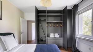 A bedroom with a bed, a wardrobe, and a window.
