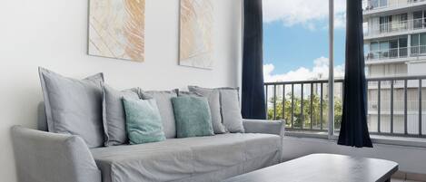 A modern living room with a grey sofa, a black coffee table, and two abstract paintings on the wall.