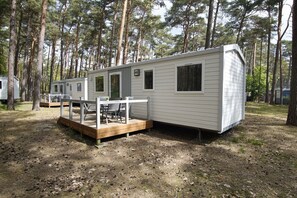 A mobile home with a deck, a small porch, and a window. - Kleines Aber Feines Ferienhäuschen in Strandnähe - Tiny Chalet Nr. 818 - Tiny Chalets (Binz)