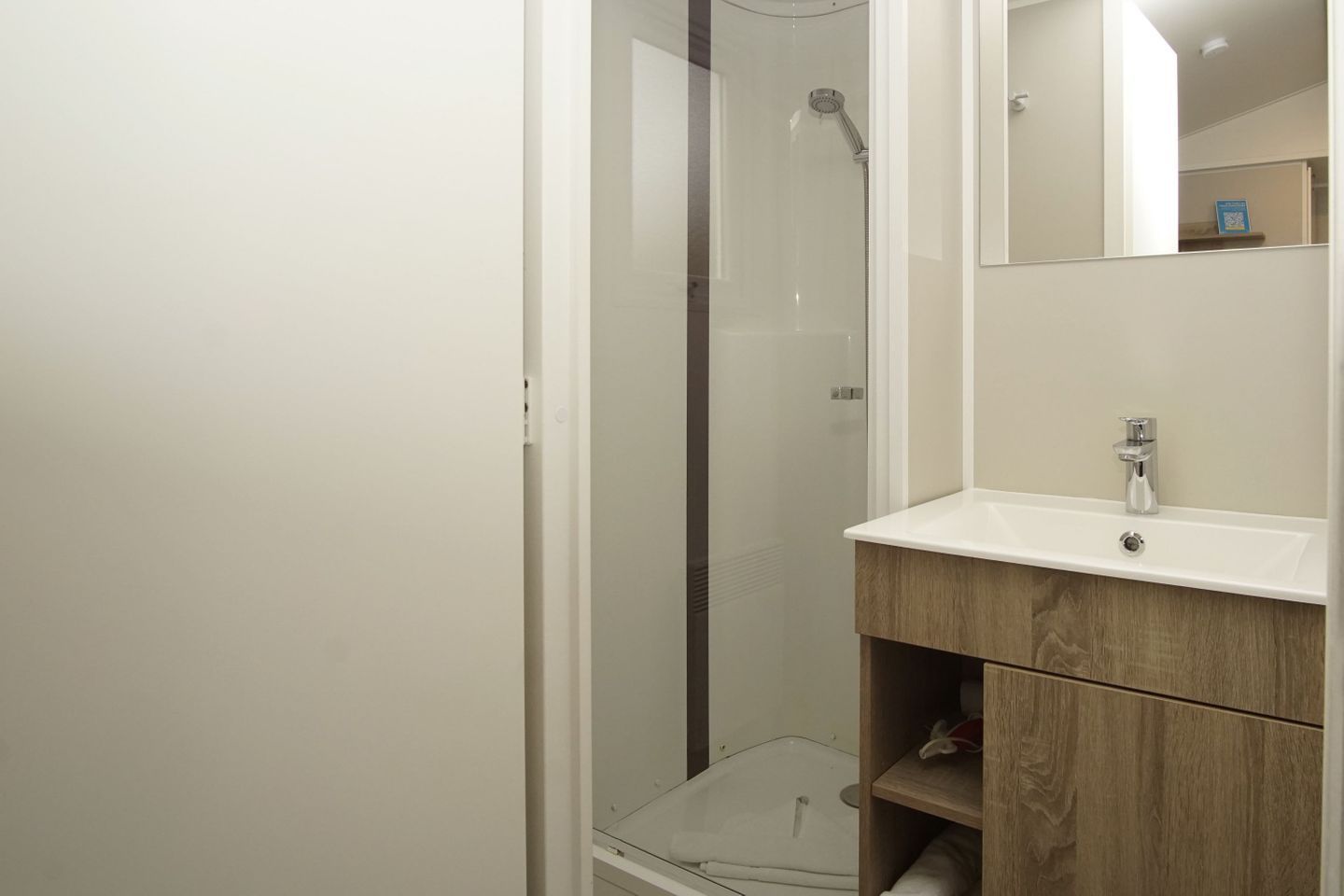 A bathroom with a shower, a sink, and a mirror.