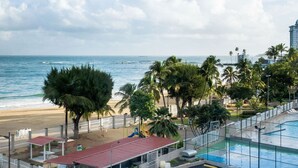 A beachfront hotel with a pool, beach access, and palm trees. - MEDIA LUNA STUDIO OCEANVIEW (Carolina)