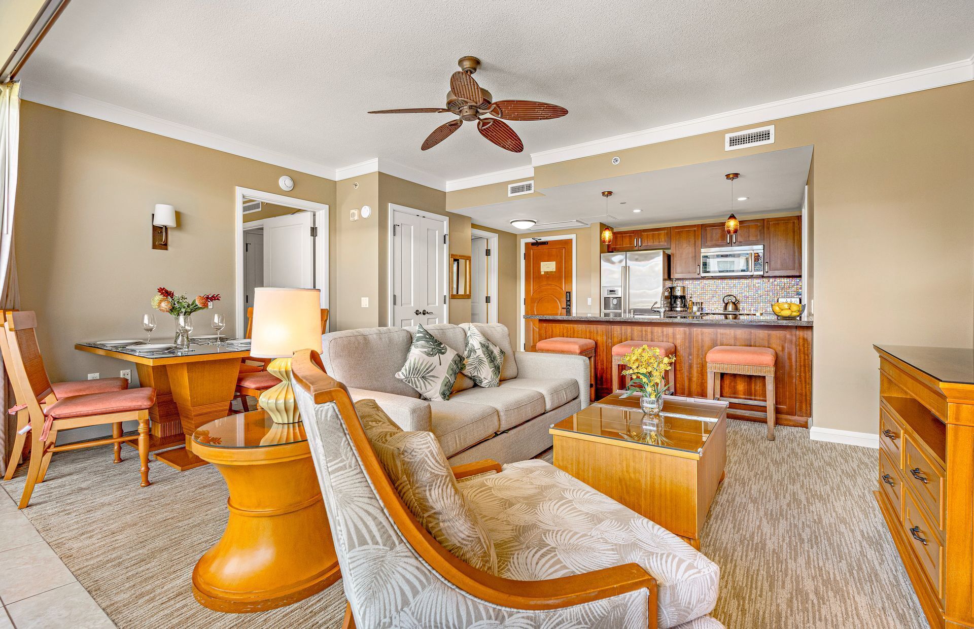 A living room with a sofa, armchairs, a coffee table, and a dining table set for two.