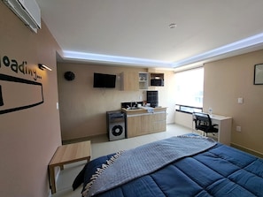 A compact hotel room with a kitchenette, a bed, a desk, and a TV. - A06 SUPER CITY SUITE AT PLAZA ACEQUIA (Cuautitlan Izcalli)