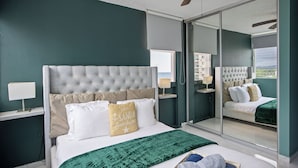 A bedroom with a large bed, a ceiling fan, and a sliding glass door leading to a balcony. - Marina Beach 2 Bd Oceanfront Pool Parking (Carolina)