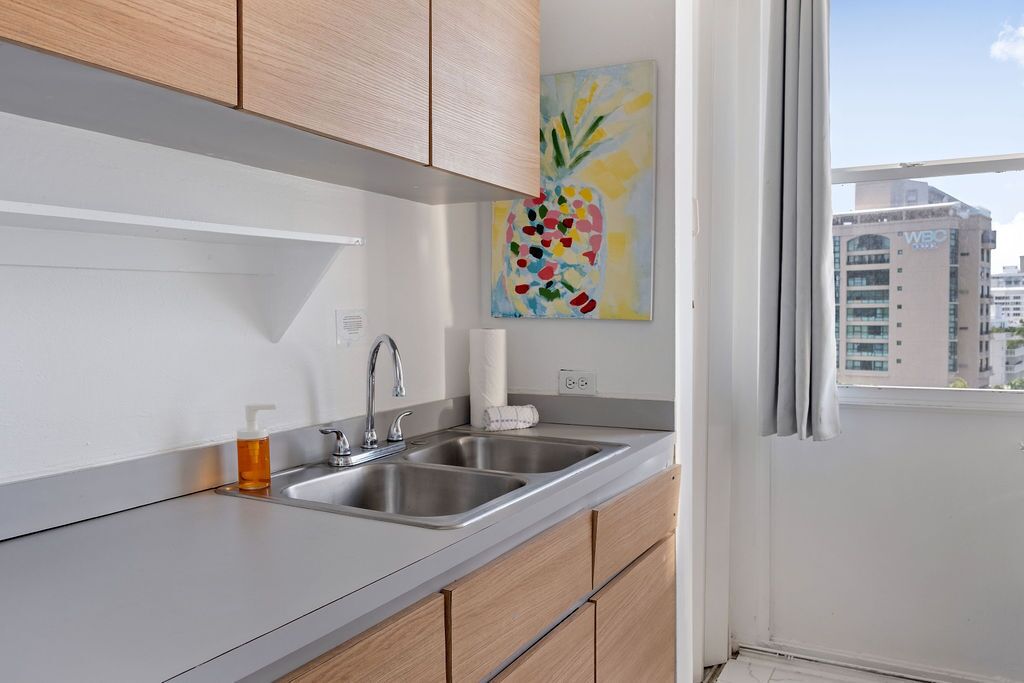 Una cocina moderna con dos fregaderos, armarios de madera y un ventanal con vista a la ciudad.