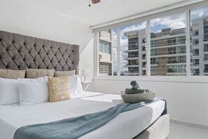 Relax in comfort with a large bed featuring a tufted headboard and plush pillows.