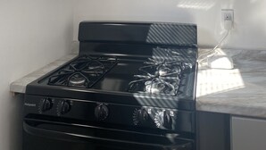 A kitchen with a stainless steel microwave and a black gas stove. - Quiet studio 10 minutes from the beach!  (Torrance)